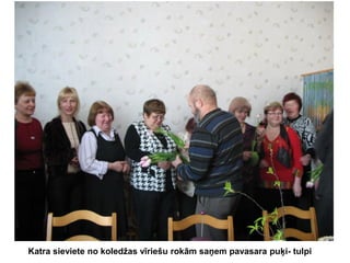 Katra sieviete no koledžas vīriešu rokām saņem pavasara puķi- tulpi

 