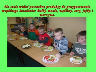 Na stole widać potrzebne produkty do przygotowania wspólnego śniadania: bułki, masło, wędliny, sery, jajka i warzywa. 
