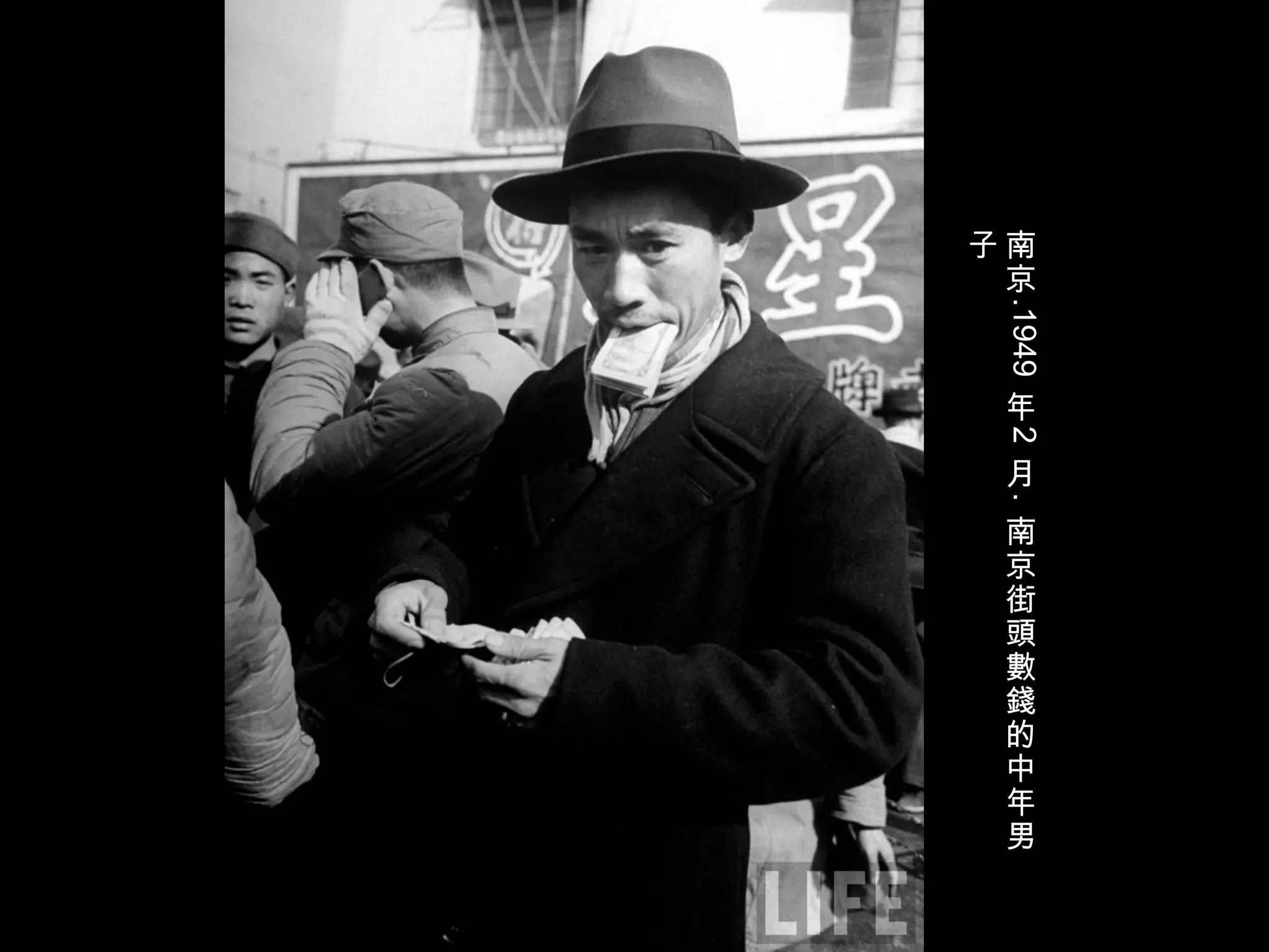 南
京
.1949
年
2
月
.
南
京
街
頭
數
錢
的
中
年
男
子
 