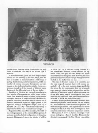 PHOTOGRAPH 2
provide better shearing action for shredding the mul­
titude of materials that may be fed to this type of
shredder.
It is understandable, given the wide range of appli­
cations and the flexibility of the basic design, that this
type of shredder is manufactured in a wide range of
cutting chamber sizes, cutter configurations, width and
number of cutters, connected horsepower, and rpm
ranges on the individual cutting shafts. However, a
common thread to all the models of different manu­
facturers is the differential rpm of the two shafts.
Shredders of this type are currently manufactured
by a number of companies and utilize either a direct
drive, from an electric motor or diesel engine driving
through a gear box, or a hydraulic dive. Hydraulically
powered units may use either electric motors or an
internal combustion engine to supply power to the
hydraulic pump(s). Horsepower ranges-from 7X. to
600 (5.6 kW-300 kW)-attest to the wide variety of
applications of this basic shear shredder design.
Regardless of the size of the shredder, the width of
the cutting segments, or the connected horsepower, all
units use a similar, helical configuration of the cutting
segment. Photograph 4, shows the interior of a 65 in.
268
X 76 in. (165 cm X 193 cm) cutting chamber in a
400 hp (300 kW) shredder. Please note that the seg­
ments shown are split into two halves and bolted
around a keyed or hexagonal shaft. However, the same
general configuration would apply ifthe segments were
stacked on the shafts from one end.
This type of shredder, because of its versatility, and
the wide range of materials that it will process suc­
cessfully, will be the most common design specified in
the future. Its low maintenance (per ton processed)
cost, apparent reduced power consumption, and the
reduction of explosion hazards when processing mu­
nicipal solid waste, make it very attractive when com­
pared to the traditional high speed hammermills for
reduction of MSW and demolition waste.
Another advantage of the low speed shredder, when
shredding to produce refuse-derived fuel for burning
in a dedicated boiler, is the relatively large mean size
of the discharge material. The larger mean size creates
voidages in the RDF bed, thus allowing for a more
complete combustion, with closer temperature control.
Photograph 5 shows a typical municipal waste
stream feeding into a Type II shredder. This particular
shredder was equipped with 4 in. (10 cm) wide cutfing
 