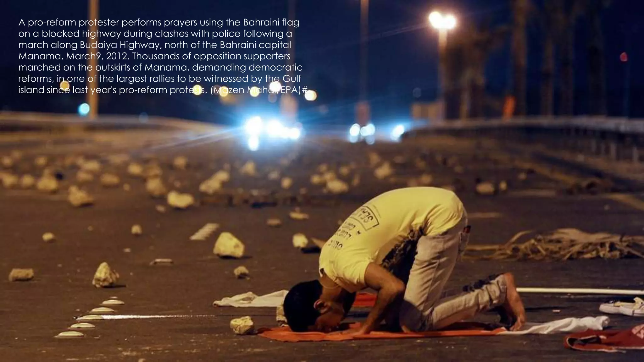 A pro-reform protester performs prayers using the Bahraini flag
on a blocked highway during clashes with police following a
march along Budaiya Highway, north of the Bahraini capital           35
Manama, March9, 2012. Thousands of opposition supporters
marched on the outskirts of Manama, demanding democratic
reforms, in one of the largest rallies to be witnessed by the Gulf
island since last year's pro-reform protests. (Mazen Mahdi/EPA)#
 