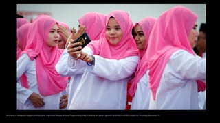 Members of Malaysia's largest political party, the United Malays National Organization, take a selfie at the party's gener...