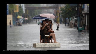 People in Manila, Philippines, take a selfie Wednesday, August 12, as they ride on a makeshift raft in a flooded street.
 