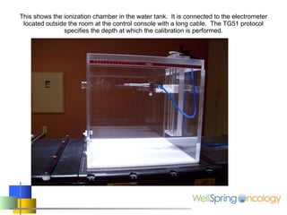 This shows the ionization chamber in the water tank.  It is connected to the electrometer located outside the room at the control console with a long cable.  The TG51 protocol specifies the depth at which the calibration is performed. 