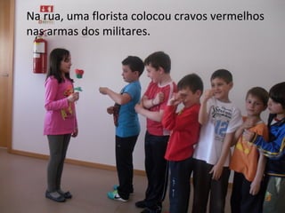 Na rua, uma florista colocou cravos vermelhos
nas armas dos militares.
 