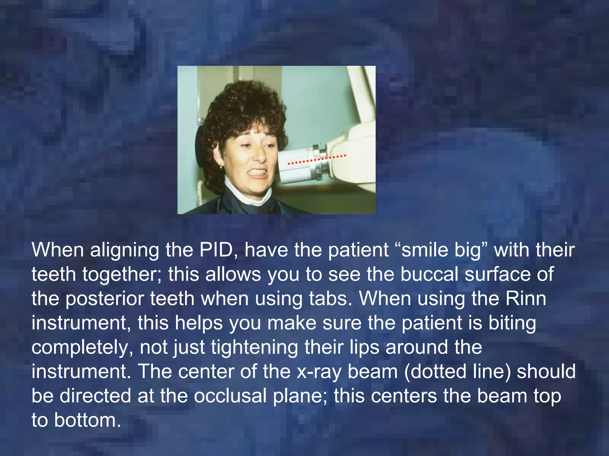 When aligning the PID, have the patient “smile big” with their
teeth together; this allows you to see the buccal surface of
the posterior teeth when using tabs. When using the Rinn
instrument, this helps you make sure the patient is biting
completely, not just tightening their lips around the
instrument. The center of the x-ray beam (dotted line) should
be directed at the occlusal plane; this centers the beam top
to bottom.
 