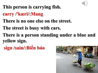This person is carrying fish.
carry /'kæri/:Mang
There is no one else on the street.
The street is busy with cars.
There is a person standing under a blue and
yellow sign.
sign /sain/:Biển báo
 