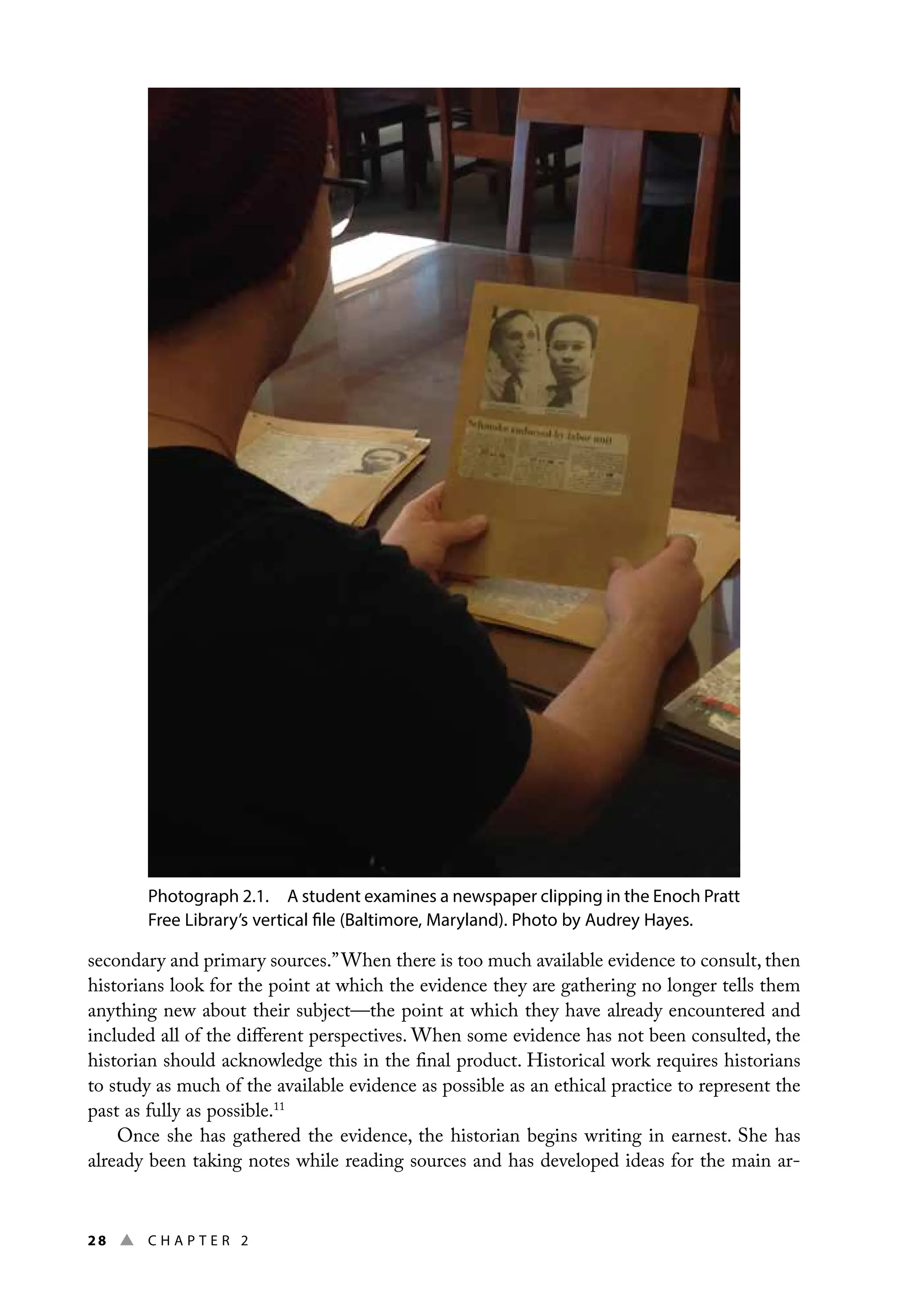 28 ▲ Chap t e r 2
Photograph 2.1. A student examines a newspaper clipping in the Enoch Pratt
Free Library’s vertical file (Baltimore, Maryland). Photo by Audrey Hayes.
secondary and primary sources.”When there is too much available evidence to consult, then
historians look for the point at which the evidence they are gathering no longer tells them
anything new about their subject—the point at which they have already encountered and
included all of the different perspectives. When some evidence has not been consulted, the
historian should acknowledge this in the final product. Historical work requires historians
to study as much of the available evidence as possible as an ethical practice to represent the
past as fully as possible.11
Once she has gathered the evidence, the historian begins writing in earnest. She has
already been taking notes while reading sources and has developed ideas for the main ar-
 