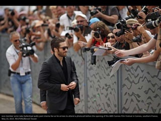 Jury member actor Jake Gyllenhaal walks past cinema fan as he arrives to attend a photocall before the opening of the 68th...