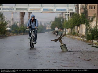 A resident rides his bicycle near what activists said was an exploded cluster bomb shell in the town of Douma, eastern Gho...