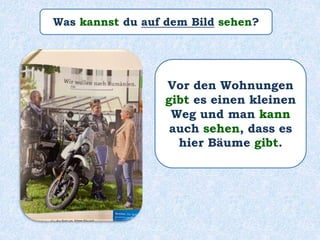 Was kannst du auf dem Bild sehen?
Vor den Wohnungen
gibt es einen kleinen
Weg und man kann
auch sehen, dass es
hier Bäume gibt.
 