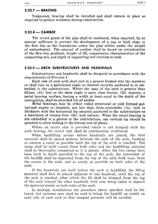 2.23.7 -BRACING
Temporary bracing shall be installed and shall remain in place as
required to protect workmen during construction.
2.23.8 - CAMBER
The invert grade of the pipe shall be cambered, when required, by an
amount sufficient to prevent the development of a sag or back slope in
the flow line as the foundation under the pipe settles under the weight
of embankment. The amount of camber shall be based on consideration
of the flow-line gradient, height of fill, compressive characteristics of the
supporting soil, and depth of supporting soil stratum to rock.
2.23.9 - ARCH SUBSTRUCTURES AND HEADWALLS
Substructures and headwalls shall be designed in accordance with the
requirements of Division I.
Each side of each arch shall rest in a groove formed into the masonry
or shall rest on a galvanized angle or channel securely anchored to or em-
bedded in the substructure. Where the span of the arch is greater than
fifteen (15) feet or the skew angle is more than twenty (20) degrees, a
metal bearing surface, having a width at least equal to the depth of the
corrugation, shall be provided for all arches.
Metal bearings may be either rolled structural or cold formed gal-
vanized angles or channels, not less than three-sixteenths (~6) inch in
thickness with the horizontal leg securely anchored to the substructure on
a maximum of twenty-four (24) inch centers. When the metal bearing is
not embedded in·a groove in the substructure, one vertical leg should be
punched to allow bolting to the bottom row of plates.
Where an invert slab is provided which is not integral with the
arch footing, the invert slab shall be continuously reinforced.
When backfilling arches before headwalls are placed, the first
material shall be placed midway between the ends of the arch, forming
as narrow a ramp as possible until the top of the arch is reached. The
ramp shall be built evenly from both sides and the backfilling material
shall be thoroughly compacted as it is placed. After the two ramps have
been built to depth specified to the top of the arch, the remainder of
the backfill shall be deposited from the top of the arch both ways from
the center to the ends, and as evenly as possible on both sides of the
arch.
If the headwalls are built before the arch is backfilled, the filling
material shall first be placed adjacent to one headwall, until the top of
the arch is reached, after which the fill shall be dumped from the top
of the arch toward the other headwall, with care being taken to deposit
the material evenly on both sides of the arch.
In multiple installations the procedure above specified shall be fol-
lowed, but extreme care shall be used to bring the backfill up evenly on
each side of each arch so that unequal pressure will be avoided.
 