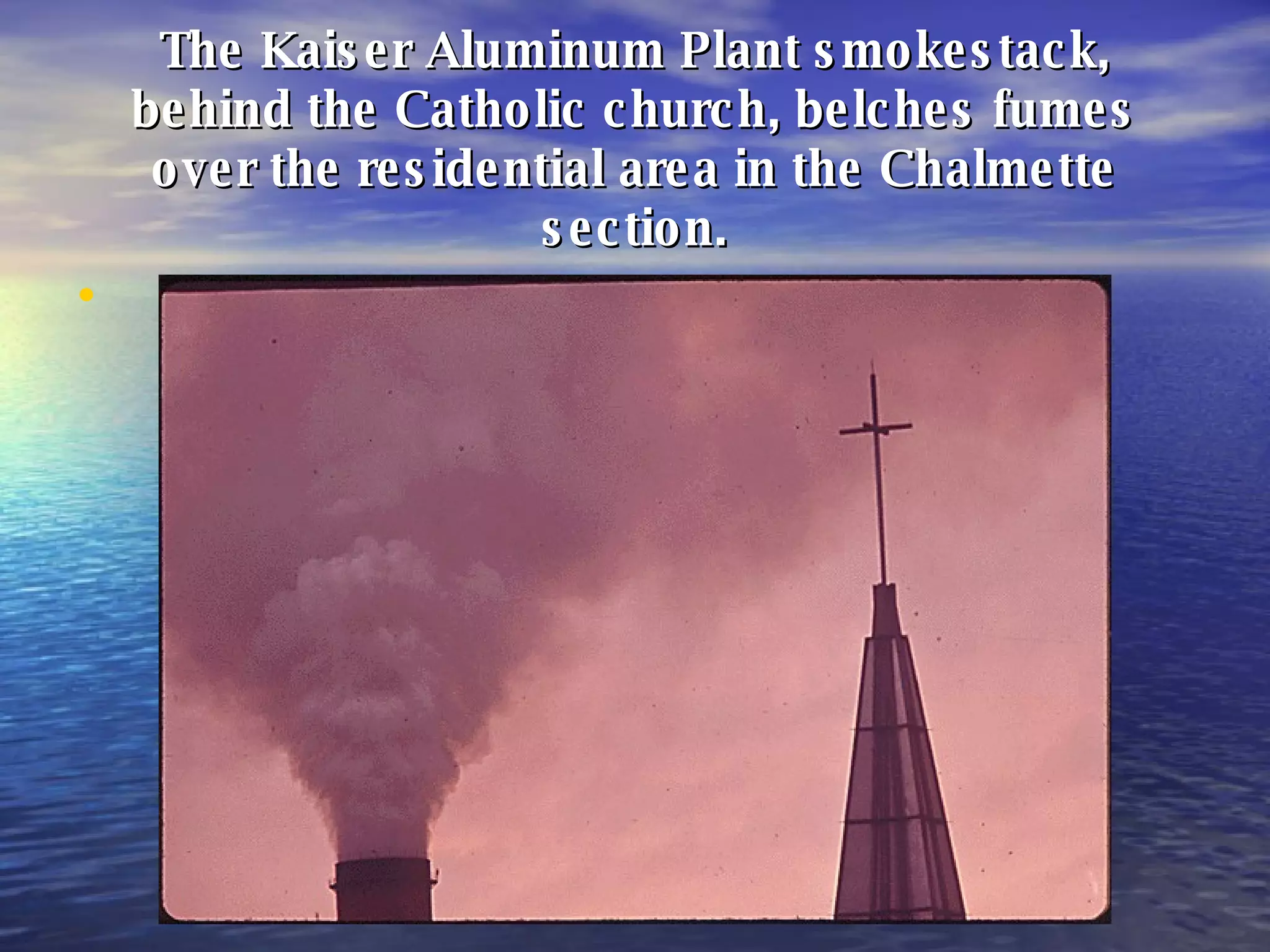 The Kaiser Aluminum Plant smokestack, behind the Catholic church, belches fumes over the residential area in the Chalmette section. 