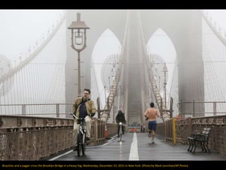 Bicyclists and a jogger cross the Brooklyn Bridge in a heavy fog, Wednesday, December 23, 2015 in New York. (Photo by Mark...