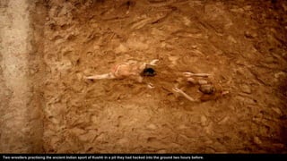 Two wrestlers practising the ancient Indian sport of Kushti in a pit they had hacked into the ground two hours before.
 