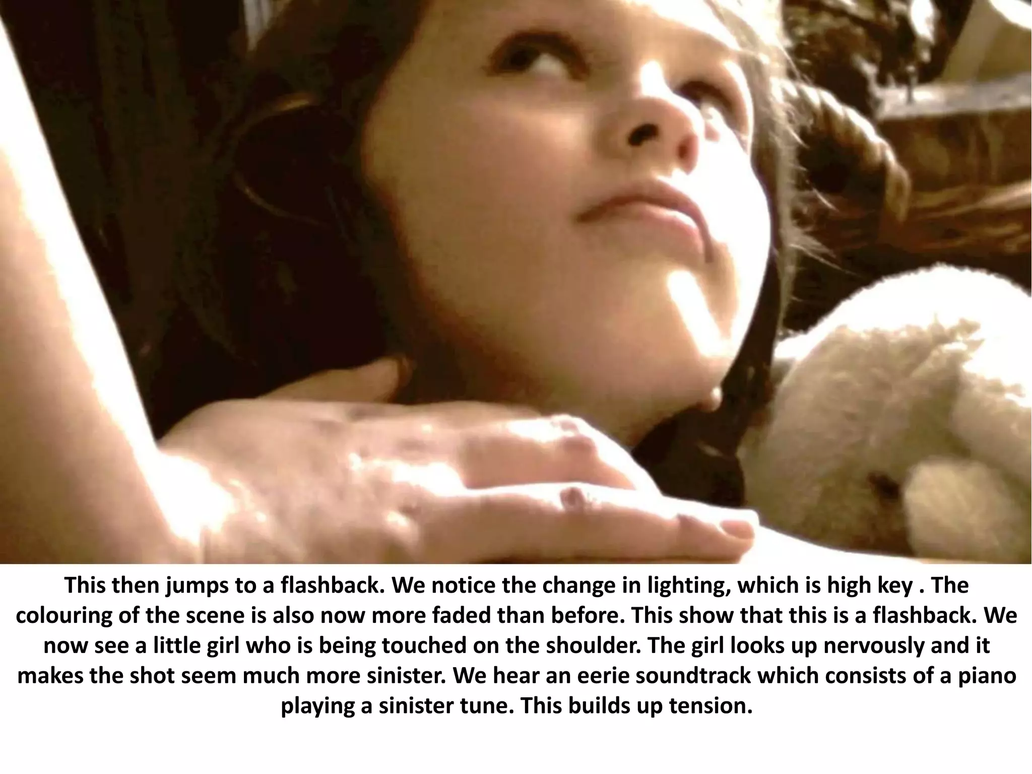	This then jumps to a flashback. We notice the change in lighting, which is high key . The colouring of the scene is also now more faded than before. This show that this is a flashback. We now see a little girl who is being touched on the shoulder. The girl looks up nervously and it makes the shot seem much more sinister. We hear an eerie soundtrack which consists of a piano playing a sinister tune. This builds up tension.