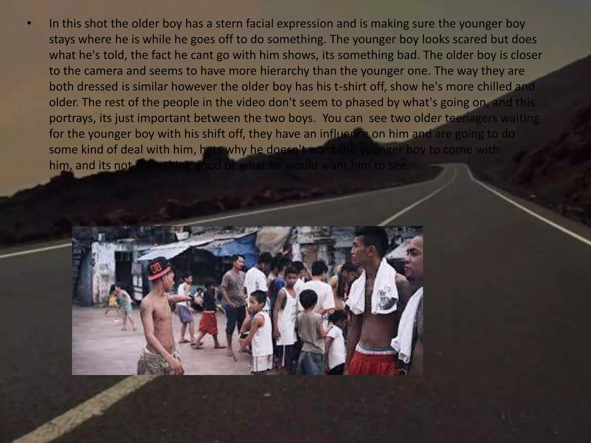 • In this shot the older boy has a stern facial expression and is making sure the younger boy
stays where he is while he goes off to do something. The younger boy looks scared but does
what he's told, the fact he cant go with him shows, its something bad. The older boy is closer
to the camera and seems to have more hierarchy than the younger one. The way they are
both dressed is similar however the older boy has his t-shirt off, show he's more chilled and
older. The rest of the people in the video don't seem to phased by what's going on, and this
portrays, its just important between the two boys. You can see two older teenagers waiting
for the younger boy with his shift off, they have an influence on him and are going to do
some kind of deal with him, hats why he doesn't want the younger boy to come with
him, and its not something good or what he would want him to see.
 