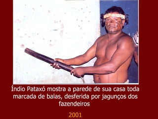 Índio Pataxó mostra a parede de sua casa toda marcada de balas, desferida por jagunços dos fazendeiros  2001 