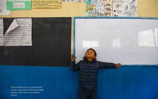 A boy stands next to a white board
inside a classroom at Khumjung High
School, also knows as the Hillary
School.
 