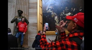 People take pictures in the rotunda after a pro-Trump mob stormed the Capitol. Saul Loeb/AFP/Getty Images
 