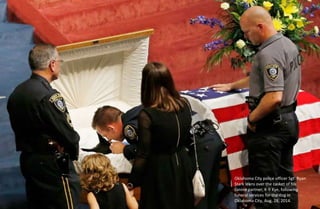 Oklahoma City police officer Sgt. Ryan
Stark leans over the casket of his
canine partner, K-9 Kye, following
funeral servi...