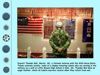 Everett Thunder Bull, Martin, SD, a Vietnam Veteran with the Wild Horse Butte Tokala veterans society, looks at a display honoring Lakota who are serving in the military on a wall at Little Wound High School in Kyle, SD. Thunder Bull dons an eagle feather, which all Lakota warriors receive when they return from war. 