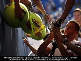 Mikhail Youzhny of Russia signs autographs for fans following his victory over Lleyton Hewitt of
Australia at the U.S. Ope...