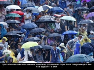 Spectators wait under their umbrellas as rain halts play at the U.S. Open tennis championships in New
York September 2, 20...