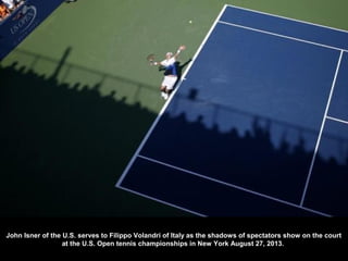 John Isner of the U.S. serves to Filippo Volandri of Italy as the shadows of spectators show on the court
at the U.S. Open...
