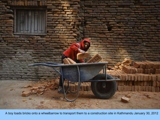 A boy loads bricks onto a wheelbarrow to transport them to a construction site in Kathmandu January 30, 2012  