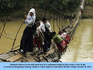 Students hold on to the side steel bars of a collapsed bridge as they cross a river to get
to school at Sanghiang Tanjung ...