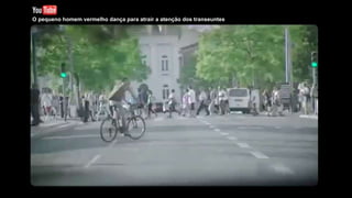 O pequeno homem vermelho dança para atrair a atenção dos transeuntes
 