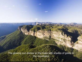 The glowing sun shines on the trees with shades of green in 
the mountains 
 