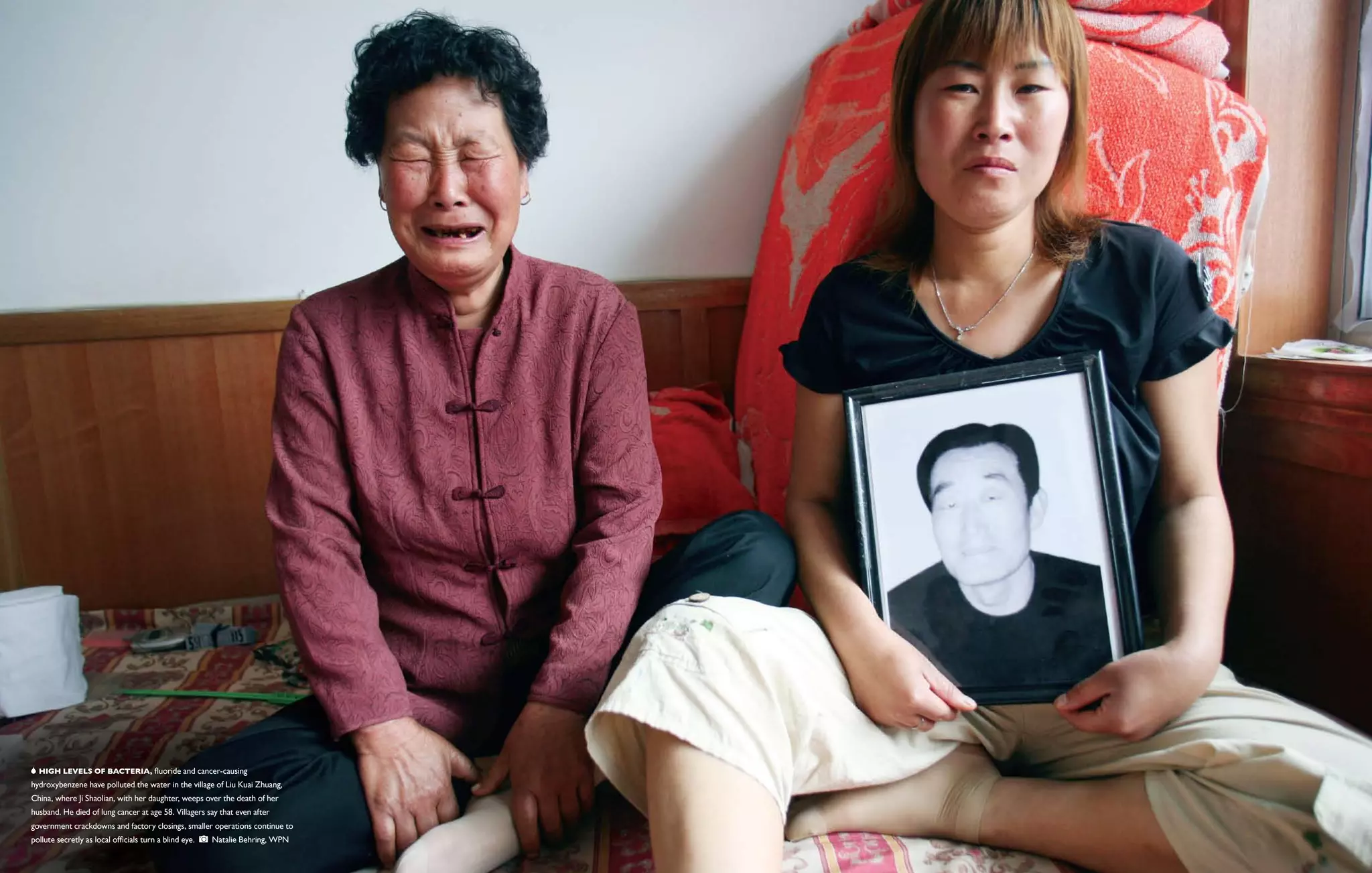   High levels of bacteria, fluoride and cancer-causing
hydroxybenzene have polluted the water in the village of Liu Kuai Zhuang,
China, where Ji Shaolian, with her daughter, weeps over the death of her
husband. He died of lung cancer at age 58. Villagers say that even after
government crackdowns and factory closings, smaller operations continue to
pollute secretly as local officials turn a blind eye.     Natalie Behring, WPN
 