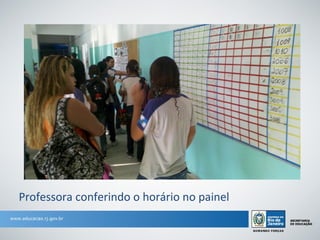 Professora conferindo o horário no painel
 