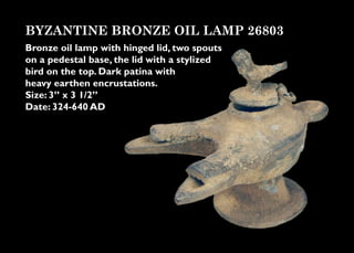 BYZANTINE BRONZE OIL LAMP 26803
Bronze oil lamp with hinged lid, two spouts
on a pedestal base, the lid with a stylized
bird on the top. Dark patina with
heavy earthen encrustations.
Size: 3” x 3 1/2”
Date: 324-640 AD
 