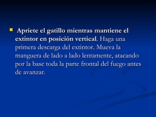 Apriete el gatillo mientras mantiene el extintor en posición vertical . Haga una primera descarga del extintor. Mueva la manguera de lado a lado lentamente, atacando por la base toda la parte frontal del fuego antes de avanzar.   