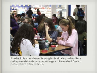 A student looks at her phone while eating her lunch. Many students like to
catch up on social media and see what’s happened during school. Another
student listens to a story being told.
 