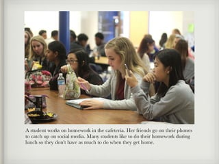 A student works on homework in the cafeteria. Her friends go on their phones
to catch up on social media. Many students like to do their homework during
lunch so they don’t have as much to do when they get home.
 