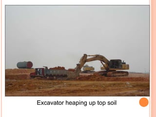 Excavator heaping up top soil
 