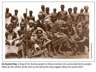 An Asante King A king of the Asante people in Ghana (center) sits surrounded by his people.
What do the clothes of the man to the left of the king suggest about his social rank?
 