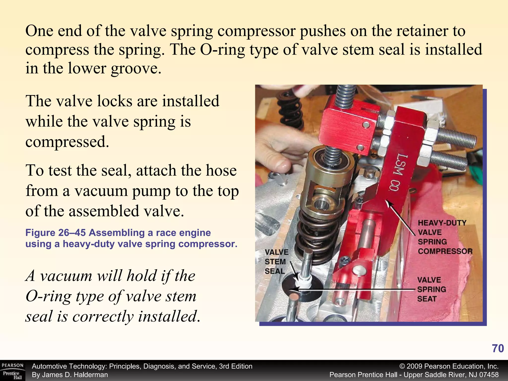 One end of the valve spring compressor pushes on the retainer to compress the spring. The O-ring type of valve stem seal is installed in the lower groove.  Figure 26–45 Assembling a race engine using a heavy-duty valve spring compressor. To test the seal, attach the hose from a vacuum pump to the top of the assembled valve.  A vacuum will hold if the O-ring type of valve stem seal is correctly installed . The valve locks are installed while the valve spring is compressed.  