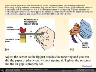 Figure 82–16  (a) Always use a nonferrous (brass or plastic) feeler (thickness) gauge when measuring the gap between the toothed ring and the wheel speed sensor.  (b) Sometimes a sensor is equipped with a paper spacer that is the exact thickness of the spacing required between the toothed ring and the sensor. If equipped, the sensor is simply installed with the paper touching the toothed wheel. A typical gap ranges from 0.020 to 0.050 in. (0.5 to 1.3 mm). Adjust the sensor so the tip just touches the tone ring and you can slip the paper or plastic out without ripping it. Tighten the setscrew and the air gap is properly set.  (a) (b) Continued 