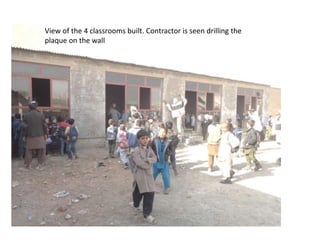 View of the 4 classrooms built. Contractor is seen drilling the
plaque on the wall
 