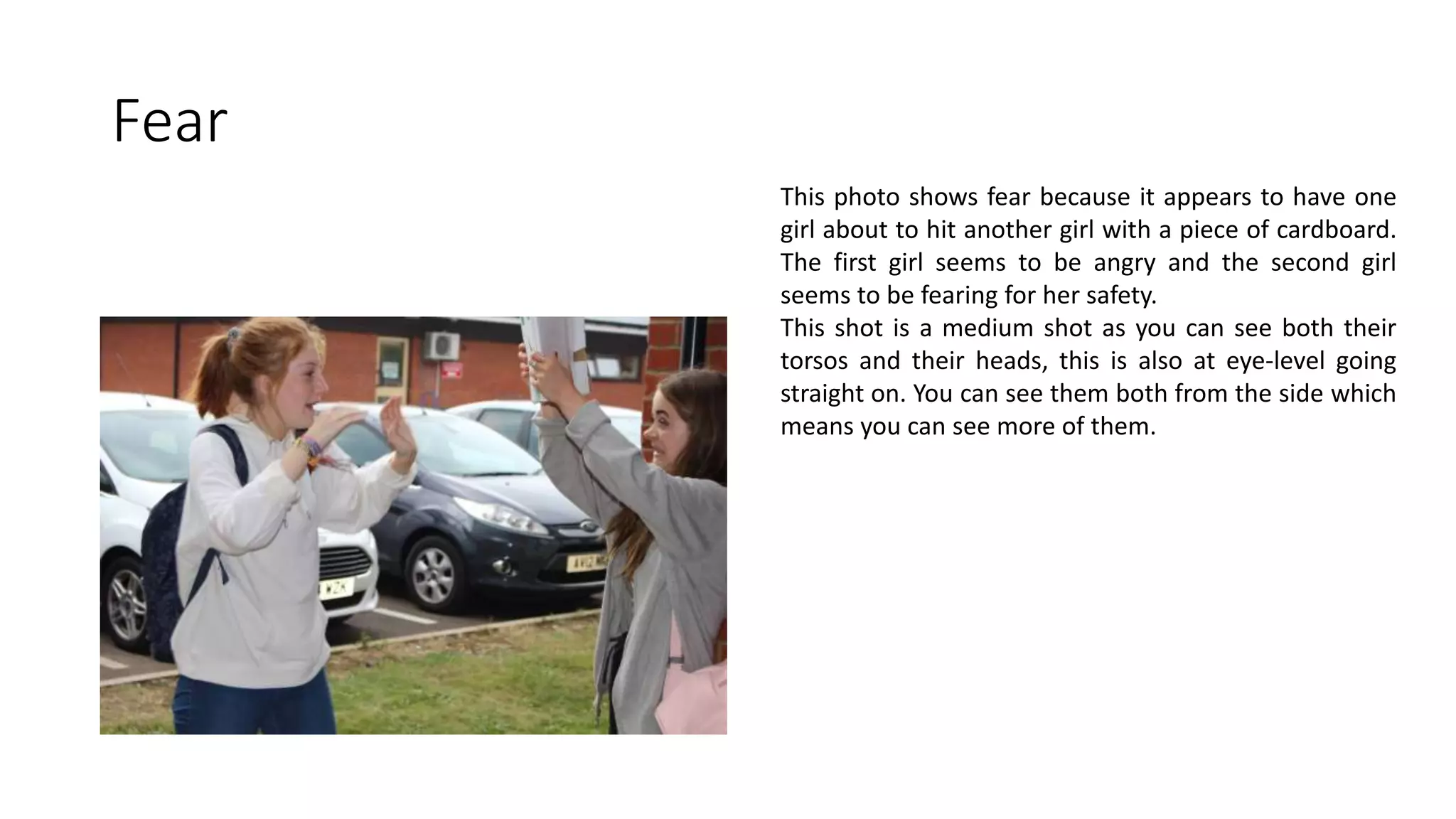 Fear
This photo shows fear because it appears to have one
girl about to hit another girl with a piece of cardboard.
The first girl seems to be angry and the second girl
seems to be fearing for her safety.
This shot is a medium shot as you can see both their
torsos and their heads, this is also at eye-level going
straight on. You can see them both from the side which
means you can see more of them.
 