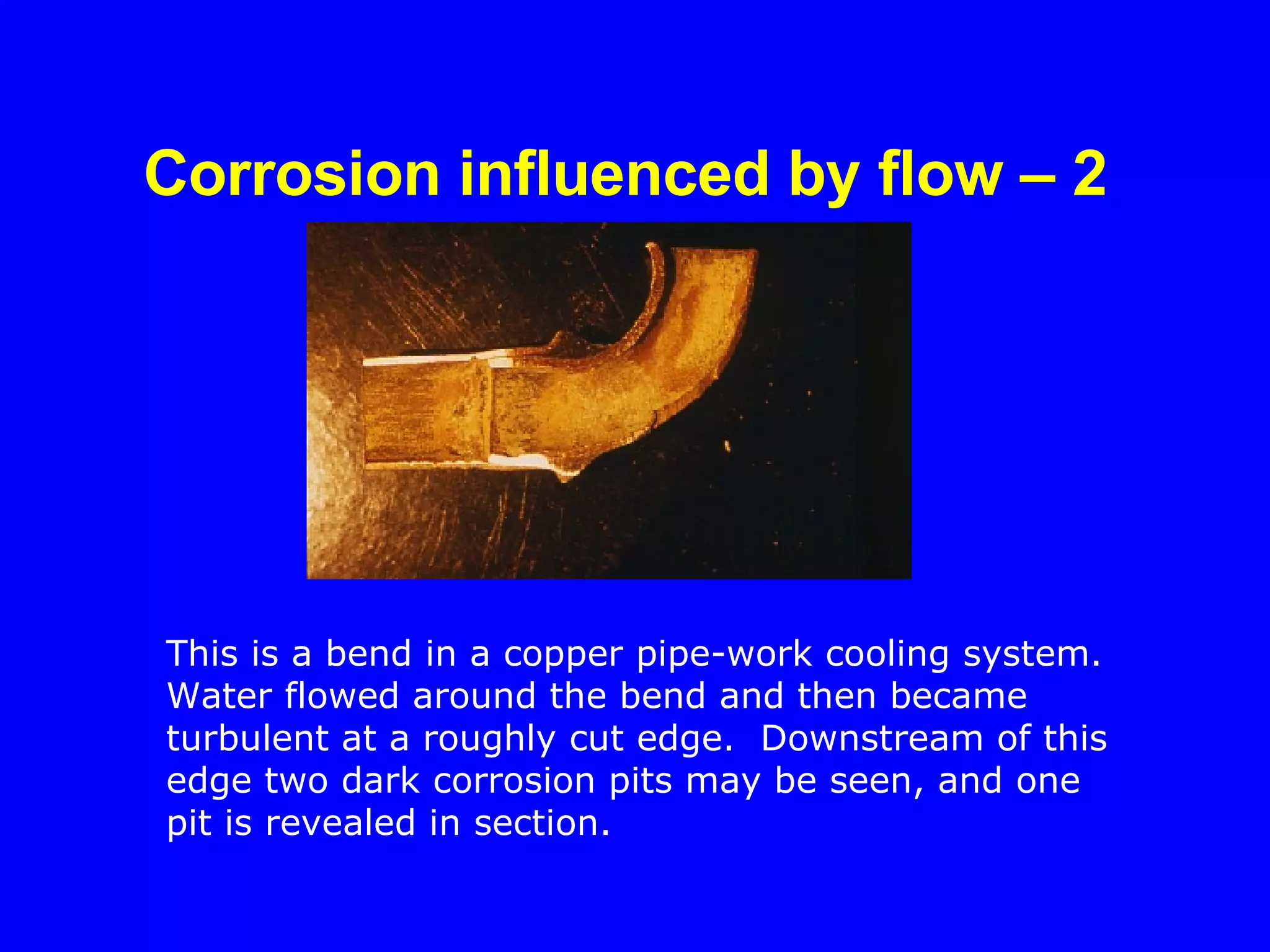 Corrosion influenced by flow – 2   This is a bend in a copper pipe-work cooling system.  Water flowed around the bend and then became turbulent at a roughly cut edge.  Downstream of this edge two dark corrosion pits may be seen, and one pit is revealed in section. 