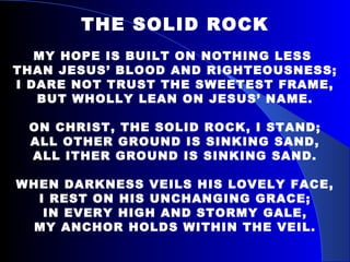 THE SOLID ROCK MY HOPE IS BUILT ON NOTHING LESS  THAN JESUS’ BLOOD AND RIGHTEOUSNESS; I DARE NOT TRUST THE SWEETEST FRAME, BUT WHOLLY LEAN ON JESUS’ NAME. ON CHRIST, THE SOLID ROCK, I STAND; ALL OTHER GROUND IS SINKING SAND, ALL ITHER GROUND IS SINKING SAND. WHEN DARKNESS VEILS HIS LOVELY FACE, I REST ON HIS UNCHANGING GRACE; IN EVERY HIGH AND STORMY GALE, MY ANCHOR HOLDS WITHIN THE VEIL. 