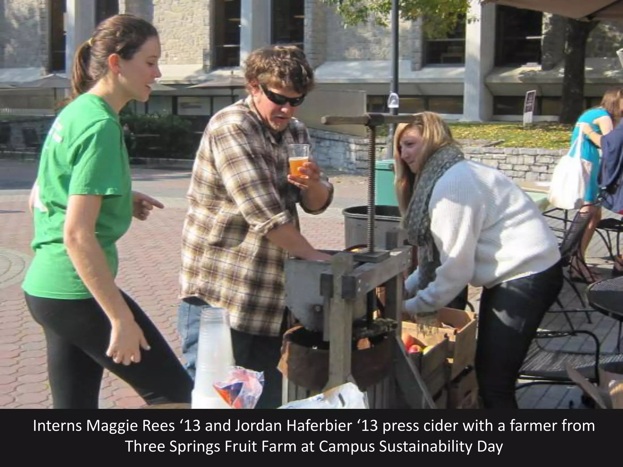 Interns Maggie Rees ‘13 and Jordan Haferbier ‘13 press cider with a farmer from
            Three Springs Fruit Farm at Campus Sustainability Day
 