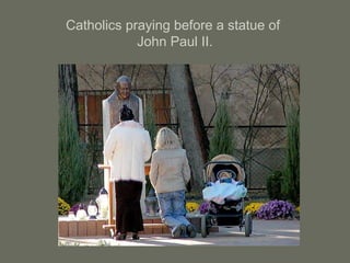 Catholics praying before a statue of
John Paul II.
 