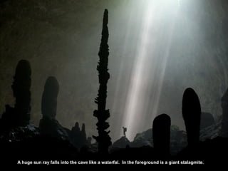 A huge sun ray falls into the cave like a waterfal. In the foreground is a giant stalagmite.
 